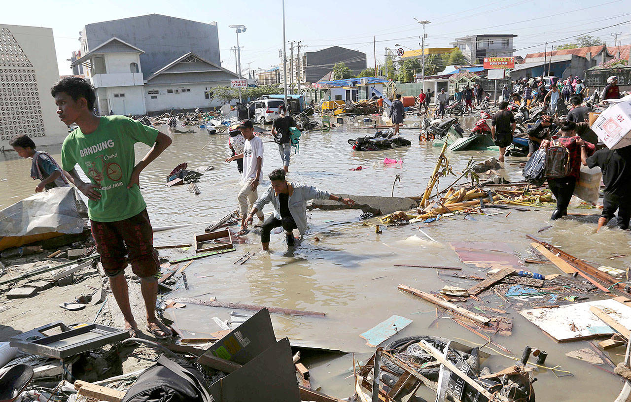People survey a damaged shopping mall following earthquakes and a tsunami in Palu, Central Sulawesi, Indonesia, on Sunday. (Tatan Syuflana / Associated Press)