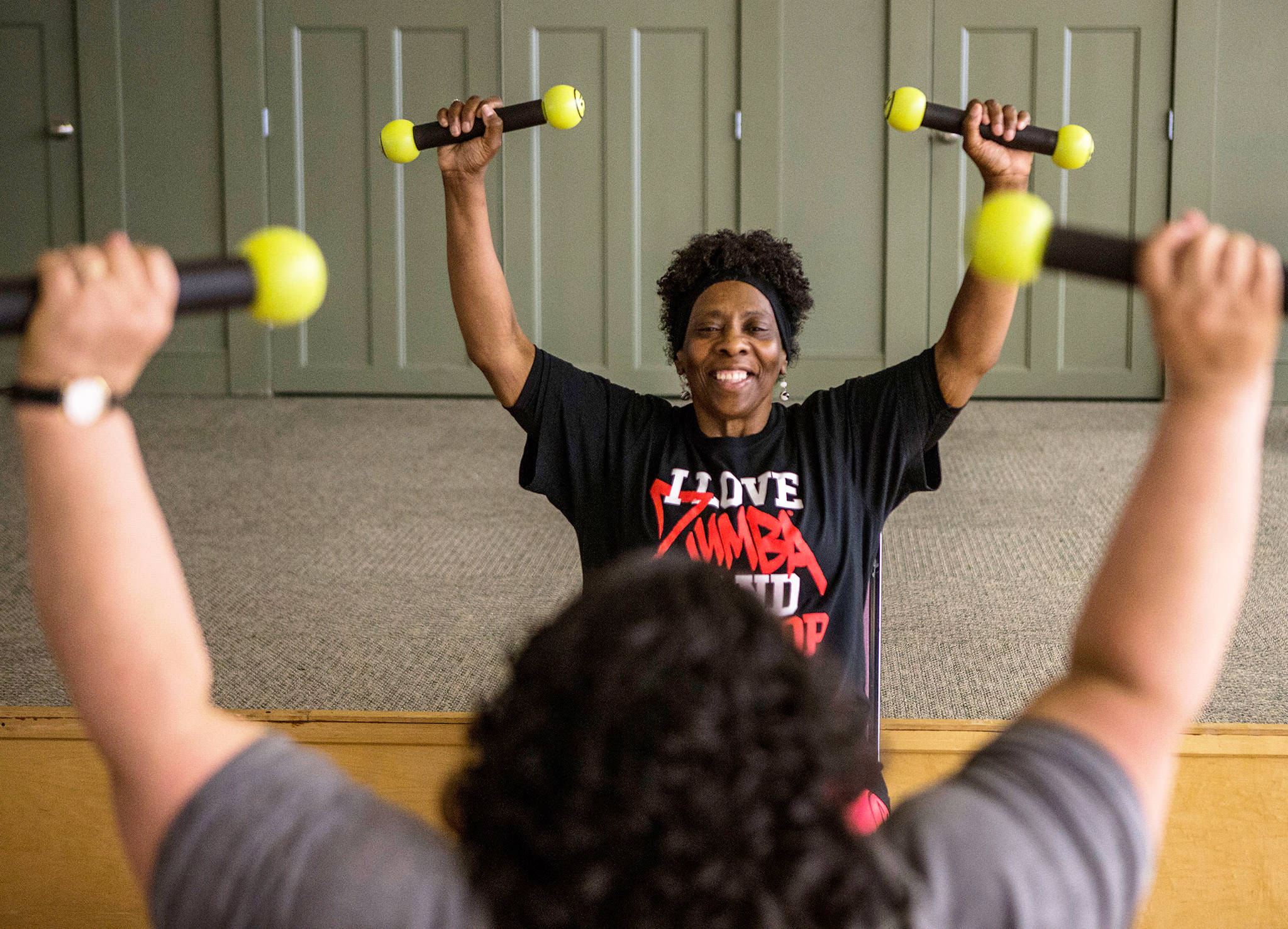 Darliene Ifiorah, 55, leads a student in exercises during a Zumba class at the Stillaguamish Senior Center in Arlington. (Olivia Vanni / The Herald)