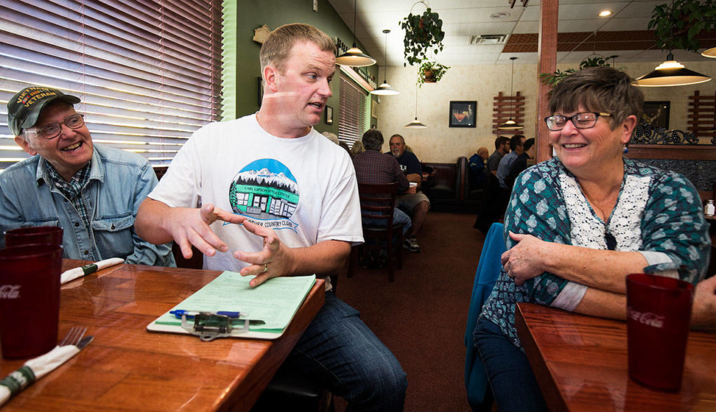 Eric Wollan gets Nancy Howard and Norman Gearhart laughing during a group trip from the Everett Senior Center to Contos Pizza Pasta on Sept. 17 in Lake Stevens as he tells a story about eating a seven-patty hamburger. (Andy Bronson / The Herald)
