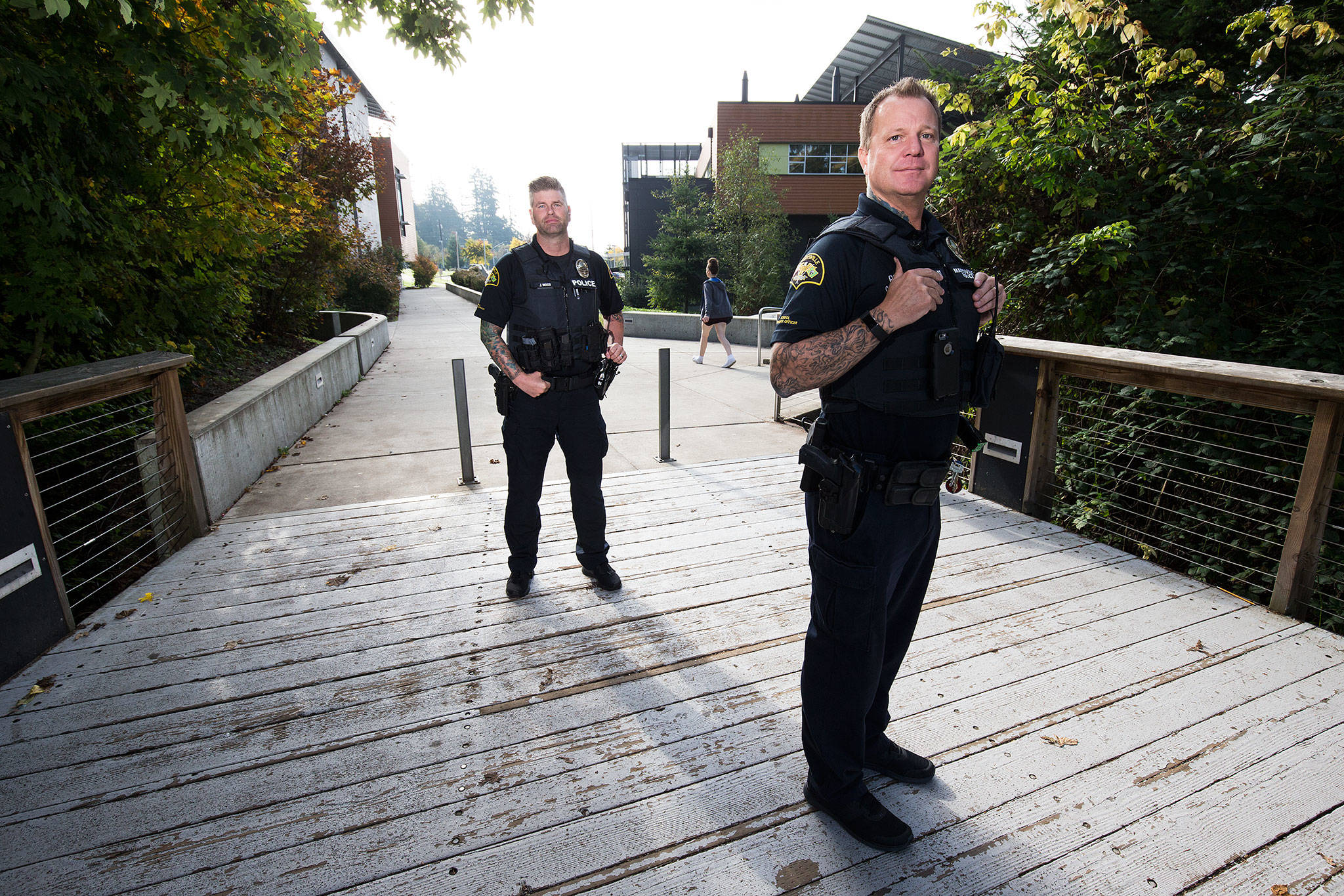 At Marysville Getchell High, School Resource Officers Chris Sutherland (right) and Jeremy Wood pose for a photo on Thursday in Marysville. Both men have been diagnosed with PTSD; Wood witnessed a shooting and later held a man as he died, and Sutherland was the first officer to go into the cafeteria after the shooting at Marysville Pilchuck High School. (Andy Bronson / The Herald)