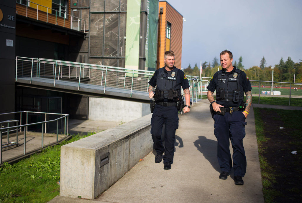 At Marysville Getchell High, School Resource Officers Chris Sutherland (right) and Jeremy Wood talk briefly before Sutherland heads back to Marysville Pilchuck High on Thursday. (Andy Bronson / The Herald)
