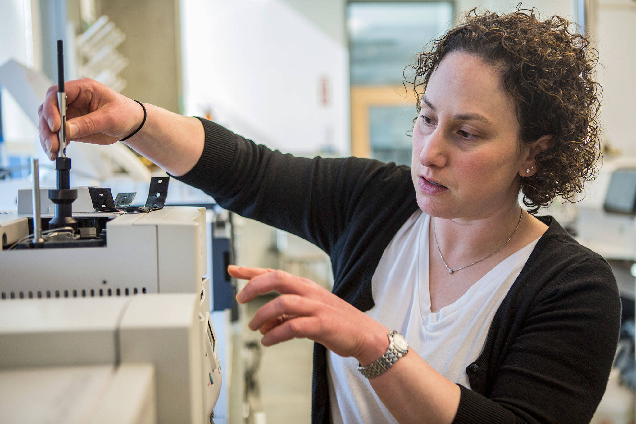 Lori Robins places a solid phase micro extraction fiber in a mass spectrometer. (Olivia Vanni / The Herald)