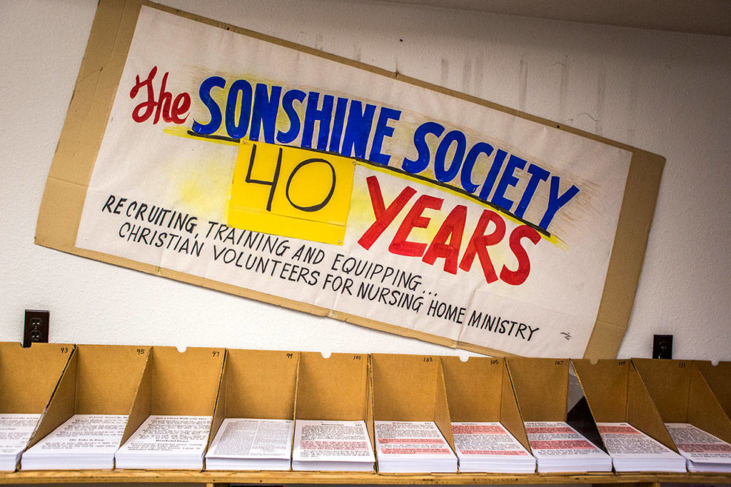 A poster celebrating 40 years of the Sonshine Society hangs above song book pages in the office on Sept. 26, 2018 in Everett, Wa. (Olivia Vanni / The Herald)
