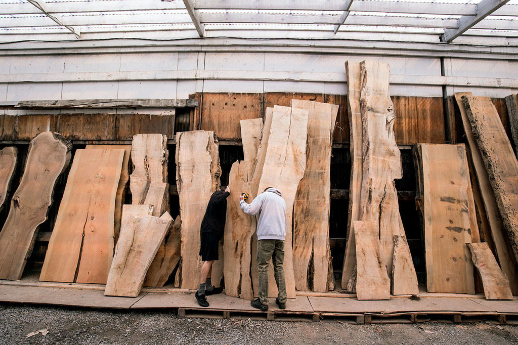 Kyle Sullivan and his father, Scott (right), examine a wood slab at Stormo Hardwoods in Everett. They were looking through the inventory for pieces to be made into a coffee table and stand-up table. (Andy Bronson / The Herald) 
