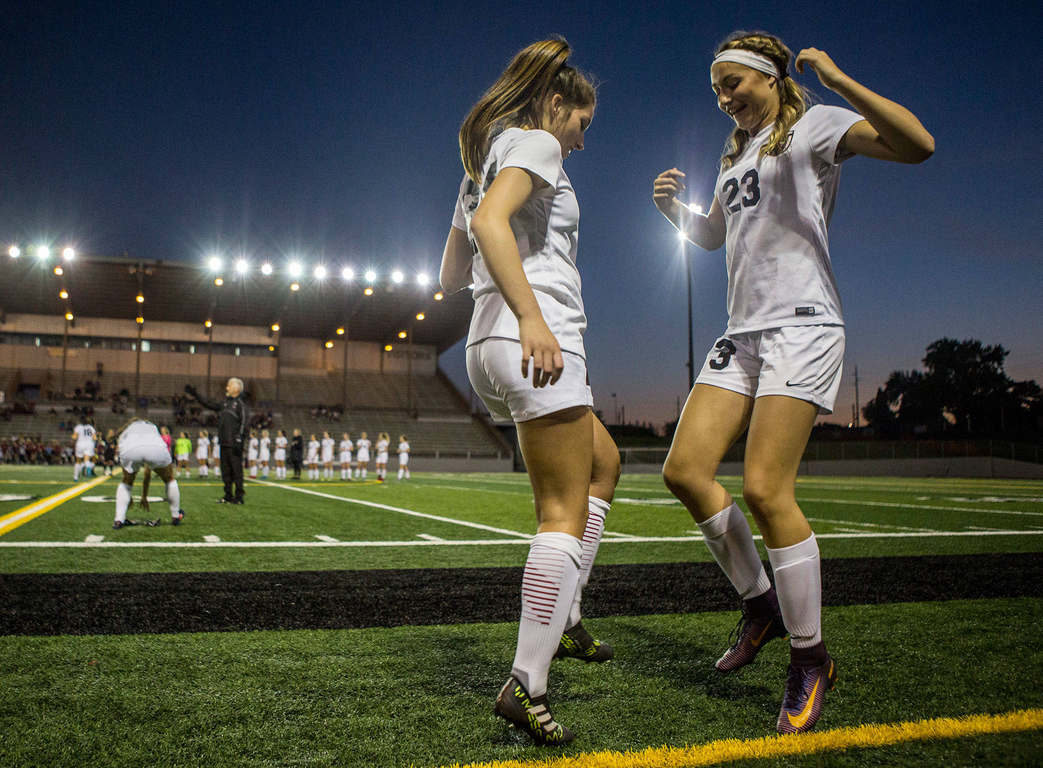 Cedarcrest’s Treena Bolin (left) and Ava Erhardt do a handshake routine before a game against Snohomish on Sept. 25, 2018, in Snohomish. (Olivia Vanni / The Herald)