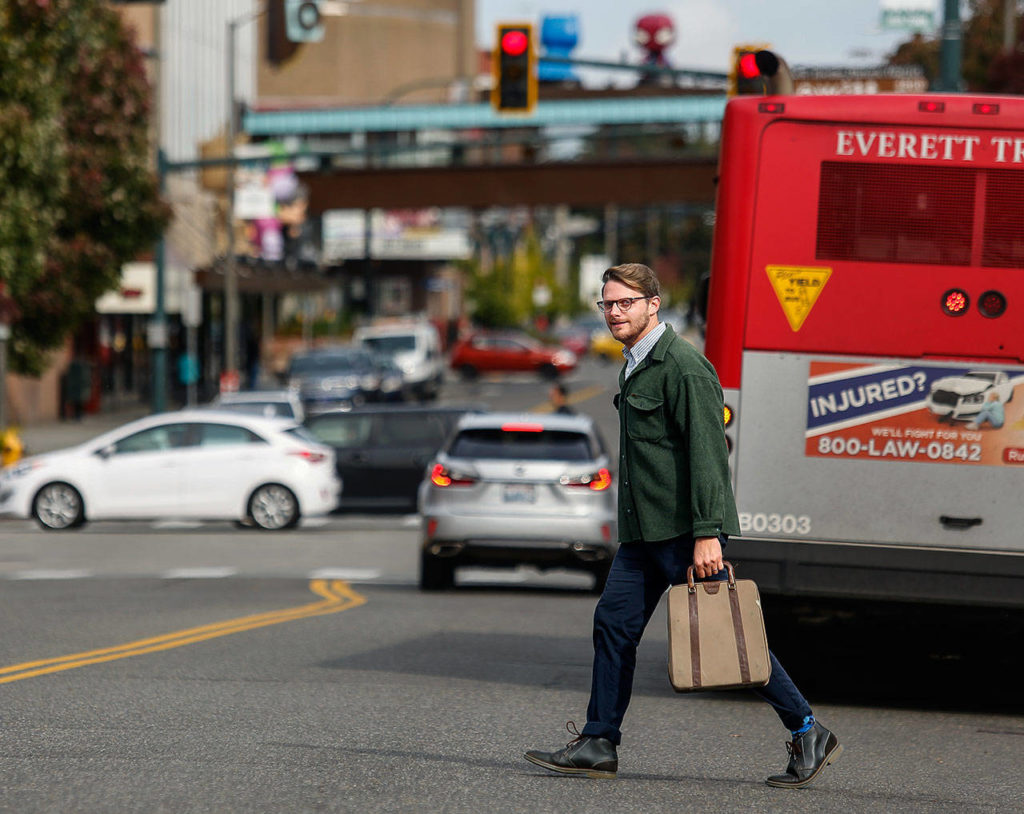 Carrying his manual typewriter, Richard Porter crosses a lively downtown Everett steet last week. A writer, he has a new book, “Smokestackers!” and has written for the blog Live in Everett. (Dan Bates / The Herald)
