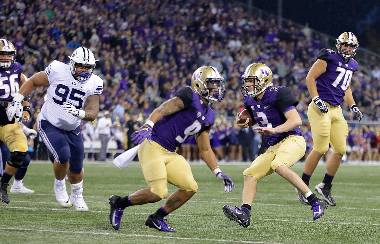 Washington quarterback Jake Browning (3) scrambles for a touchdown as offensive lineman Jared Hilbers (70) looks on during the first half of the Huskies’ 35-7 win over Brigham Young on Saturday in Seattle. (AP Photo/Ted S. Warren)