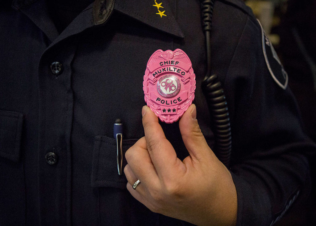 Chief Cheol Kang displays his pink Breast Cancer Awareness badge during the Mukilteo Police Department’s Coffee with a Cop on Wednesday in Mukilteo. (Olivia Vanni / The Herald)
