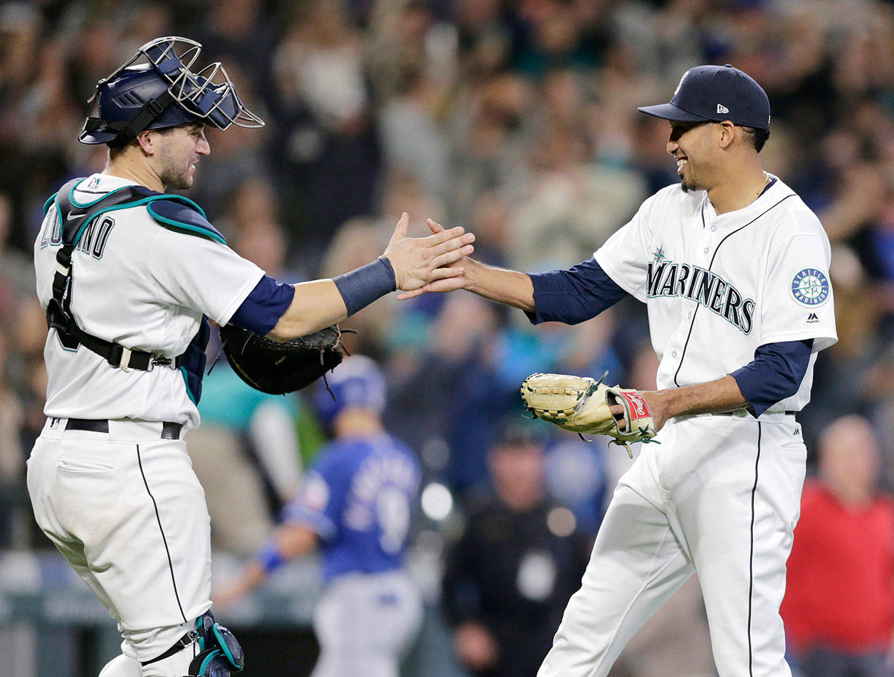 Seattle’s Edwin Diaz (right) is greeted by catcher Mike Zunino after closing out the Mariners’ Sept. 29 win over Texas in Seattle. Diaz’s ascension to stardom was a bright spot for Seattle in 2018. (AP Photo/John Froschauer)