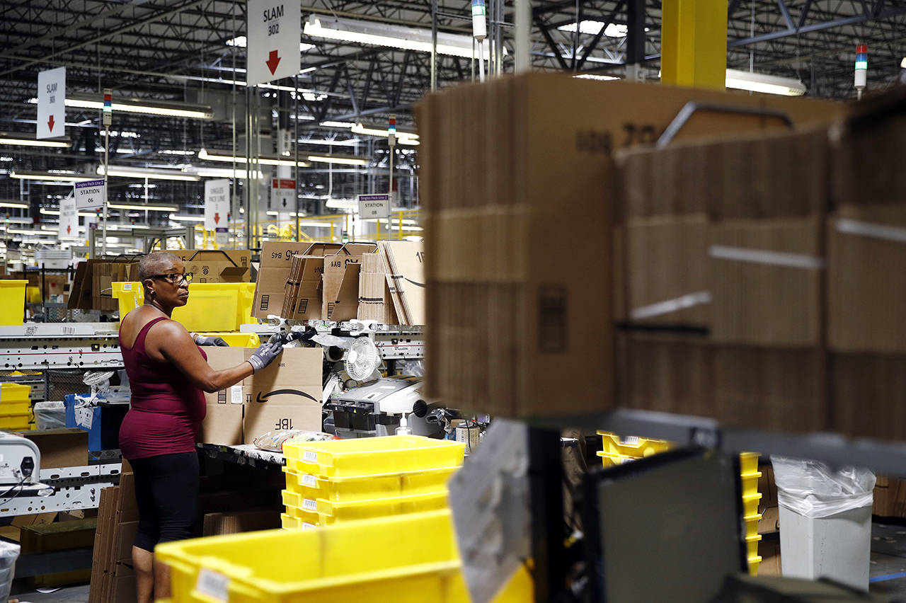In this 2017 photo, Cynthia Richburg prepares a product for shipment at an Amazon fulfillment center in Baltimore. (AP Photo/Patrick Semansky, File)