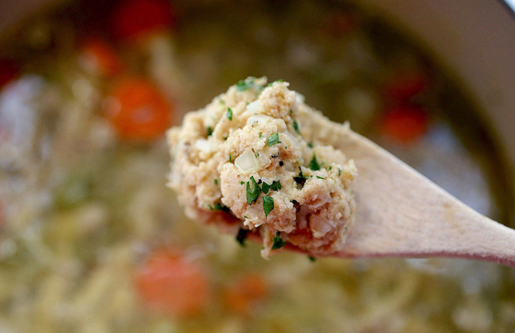 A spoonful of dumpling dough poised above the pot of chicken and dumplings. (Hillary Levin/St. Louis Post-Dispatch)
