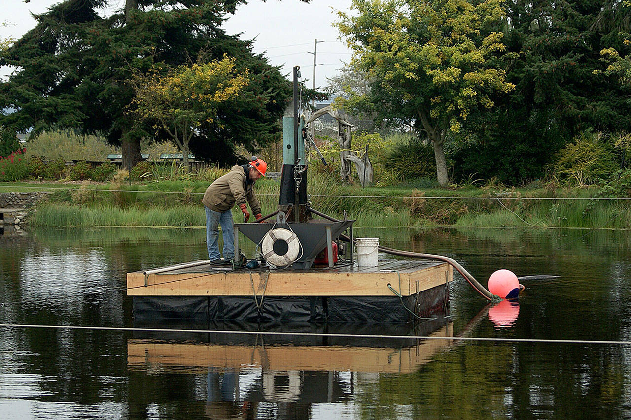 Mike Brown runs the machine that is extracting goose and duck poop from the bottom of the Greenbank Farm pond. (Maria Matson / Whidbey News Group)