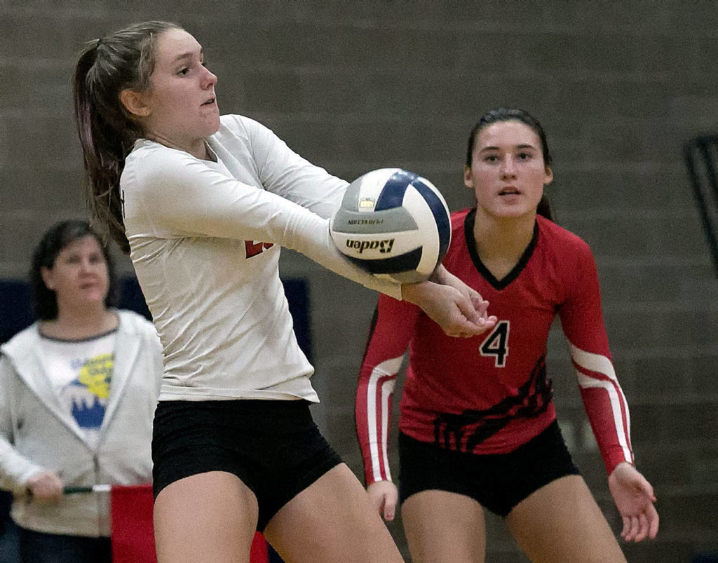 Snohomish’s Lauren Riske digs a serve with teammate Jasett Smith looking on Thursday night at Arlington High School on October 4, 2018. (Kevin Clark / The Herald)
