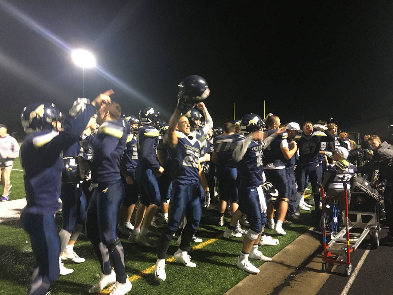 Arlington players celebrate after a 48-42 overtime win over Oak Harbor on Oct. 5, 2018, at Arlington High School. (Nick Patterson photo)