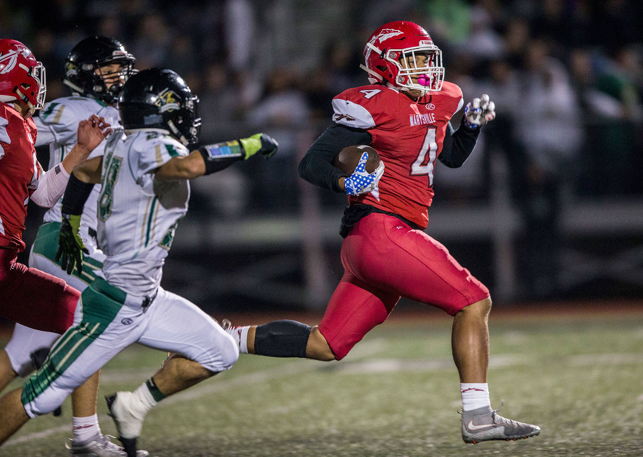 Marysville Pilchuck’s Trenton Hurst (right) runs away from Marysville Getchell defenders during the annual Berry Bowl rivalry game on Oct. 5, 2018, in Marysville. (Olivia Vanni / The Herald)