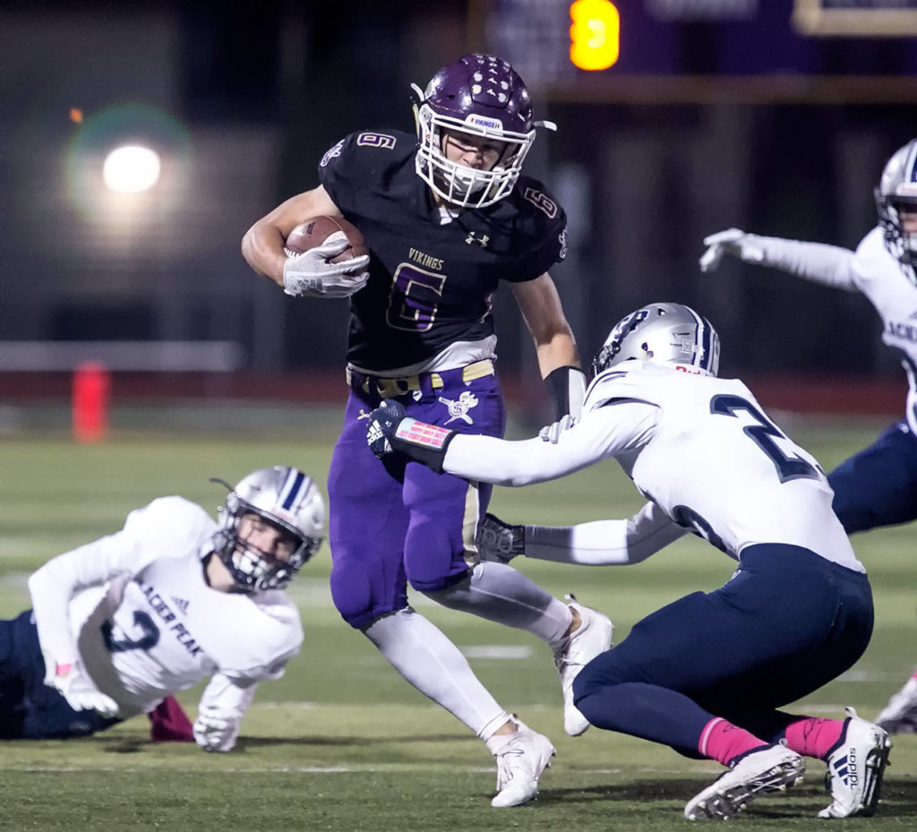 Lake Stevens’ Dallas Landeros dodges a tackle attempt by Glacier Peak’s Logan Clay Friday night at Lake Stevens High School on October 5, 2018. (Kevin Clark / The Herald)
