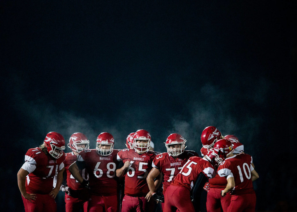 The Marysville Pilchuck offense huddles before the snap during the game on Oct. 5 in Marysville. (Olivia Vanni / The Herald)
