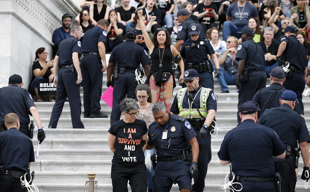 Activists are arrested by Capitol Hill Police officers after occupying the steps on the East Front of the U.S. Capitol as they protest the confirmation vote of Supreme Court nominee Brett Kavanaugh on Capitol Hill on Saturday in Washington. (AP Photo/Alex Brandon)
