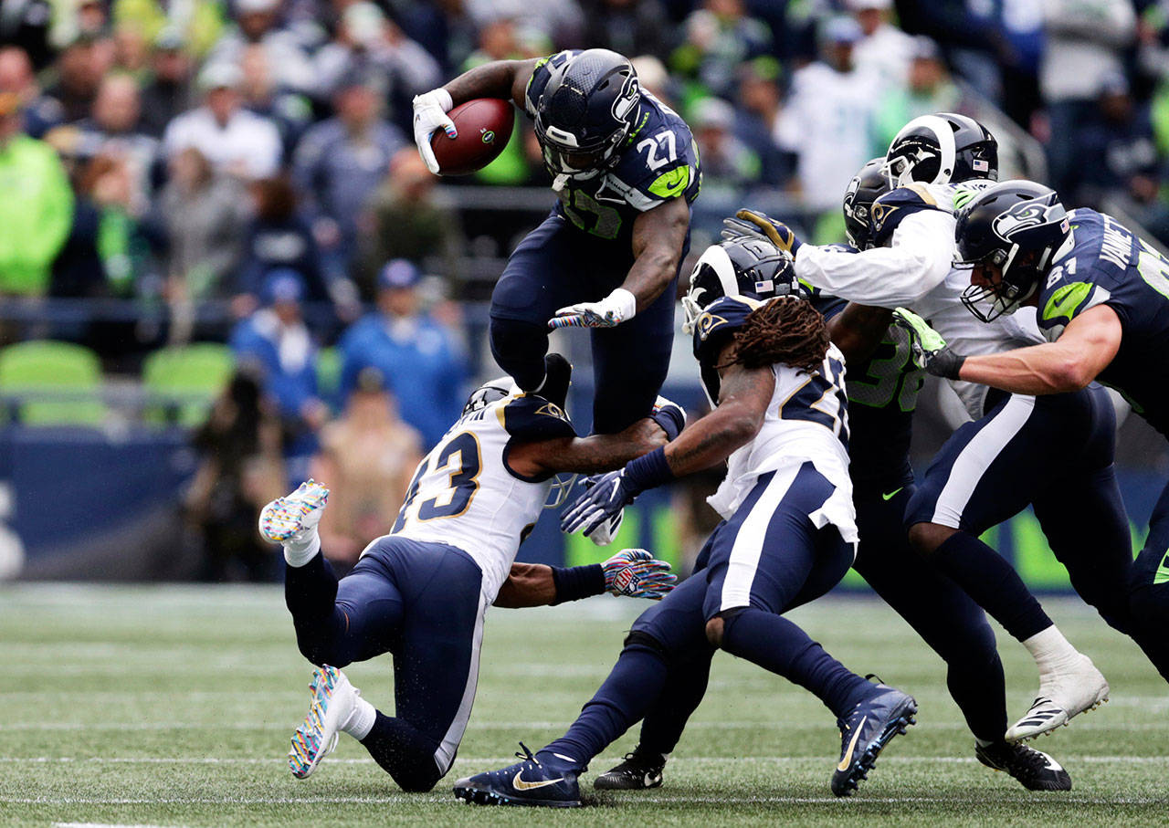 Seahawks running back Mike Davis leaps over Los Angeles Rams strong safety John Johnson during the second half of Sunday’s game in Seattle. Davis rushed for 68 yards and a touchdown on 12 carries. (AP Photo/Scott Eklund)