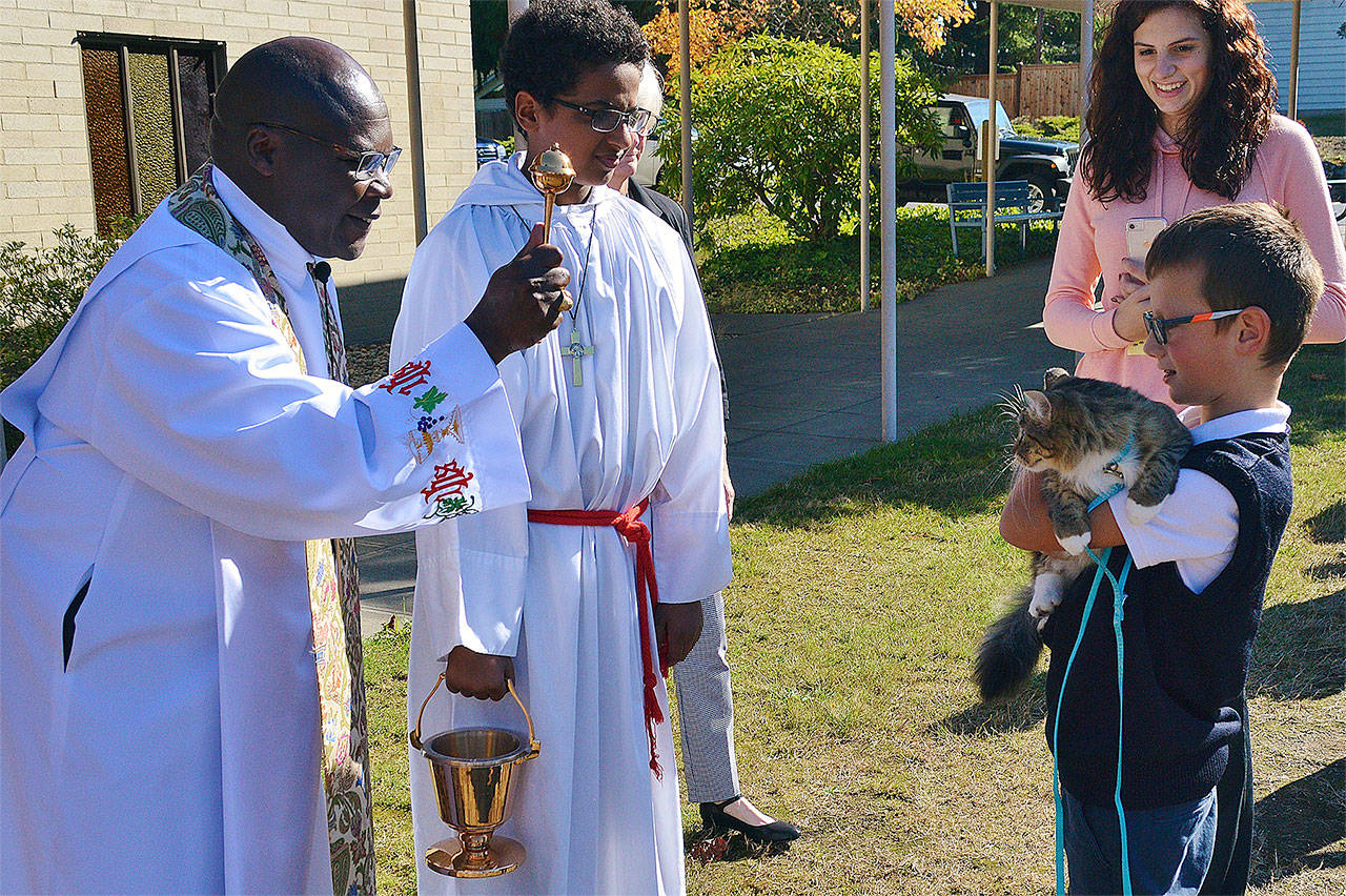 Father Stephen Okumu blesses a pet during a Blessing of the Pets celebration on Oct. 4 at St. Thomas More Parish School in Lynnwood. The celebration also included a pet food and toy drive. (Contributed photo)
