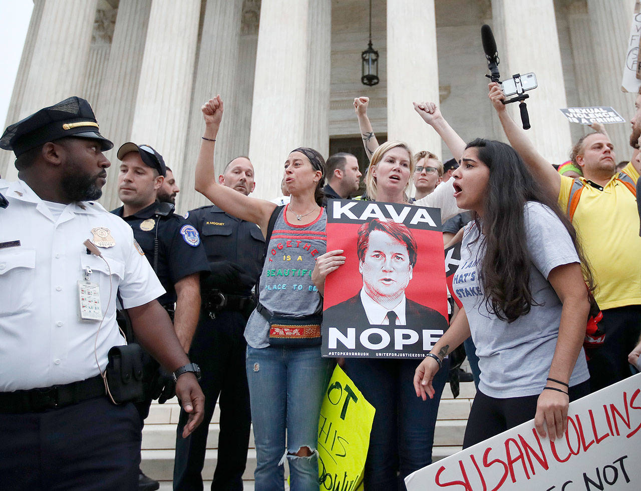 Police move activists as they protest on the steps of the Supreme Court after the confirmation vote of Supreme Court nominee Brett Kavanaugh on Saturday. (Alex Brandon / Associated Press)