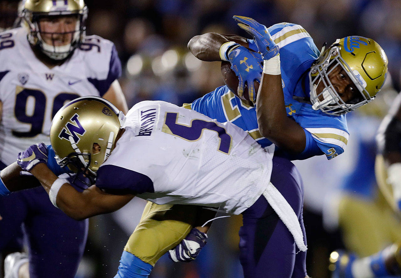 UCLA running back Joshua Kelley (top) is tackled by Washington defensive back Myles Bryant (5) during the second half of a game on Oct. 6, 2018, in Pasadena, Calif. (AP Photo/Marcio Jose Sanchez)