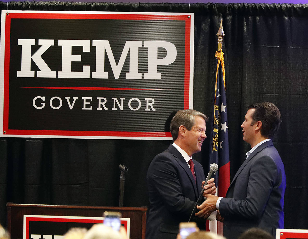 Republican nominee for Georgia Gov. Brian Kemp (left) welcomes Donald Trump Jr on stage during a campaign event Tuesday in Athens, Georgia. (AP Photo/John Bazemore)