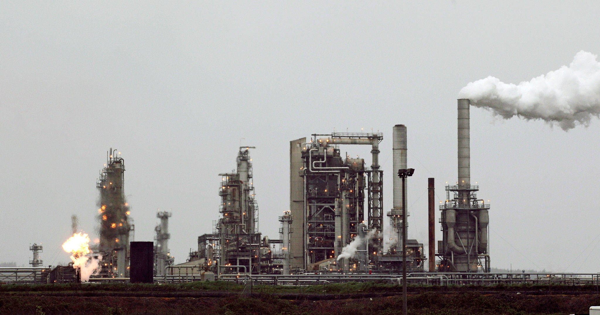 A gas flame, part of normal plant operations, flares at a refinery in April 2010, now owned by Andeavor, formerly Tesoro Corp., including a gas flare flame that is part of normal plant operations, in Anacortes. A campaign bankrolled by the oil industry has raised $20.46 million to defeat a carbon pollution fee on the ballot in Washington state aiming at tackling climate change. (Ted S. Warren/Associated Press file photo)