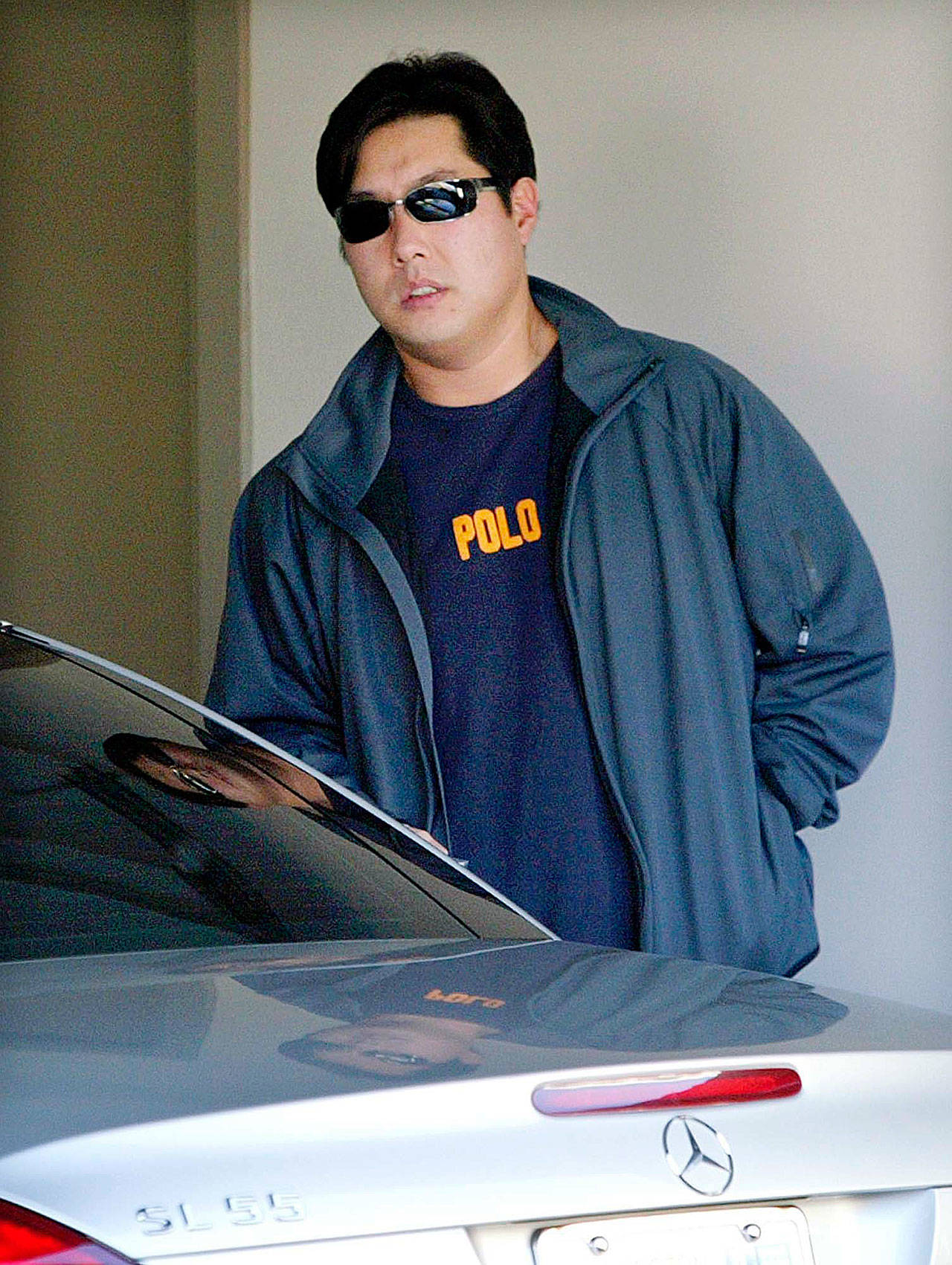 Sung “Lawrence” Hong looks up as he starts to get into one of his three luxury cars at his waterfront home in Kirkland on Feb. 10, 2006. Hong, who served nearly three years in prison for defrauding his neighbor out of about $800,000, was sentenced Wednesday to 15 years for tricking investors out of $12.7 million — a scam he and his wife began running shortly after he was released from the earlier prison term. (AP Photo/Elaine Thompson, File)
