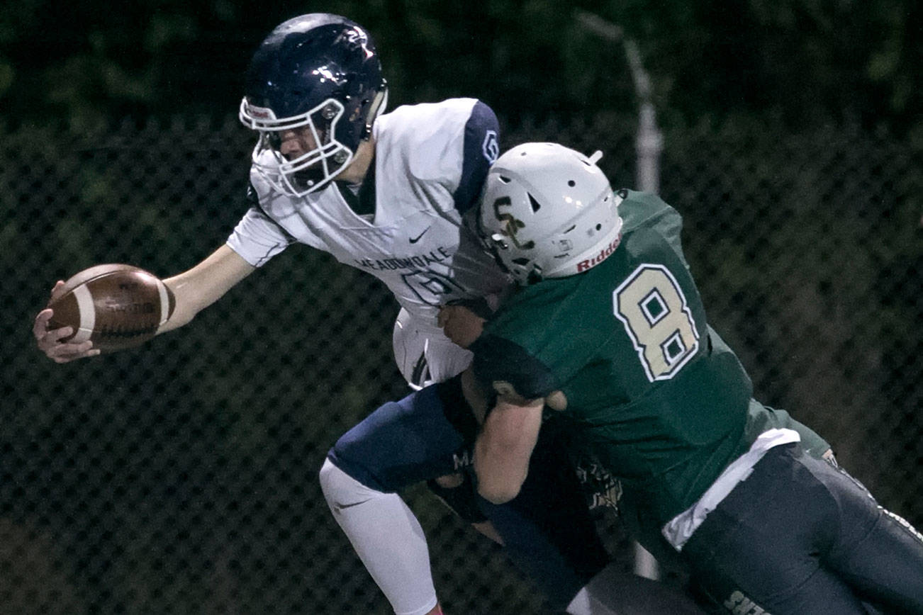 Meadowdale’s Hunter Moen reaches for extra yardage ahead of Shorecrest’s Gavin McFarlane Friday at Shoreline Stadium. (Kevin Clark / The Herald)