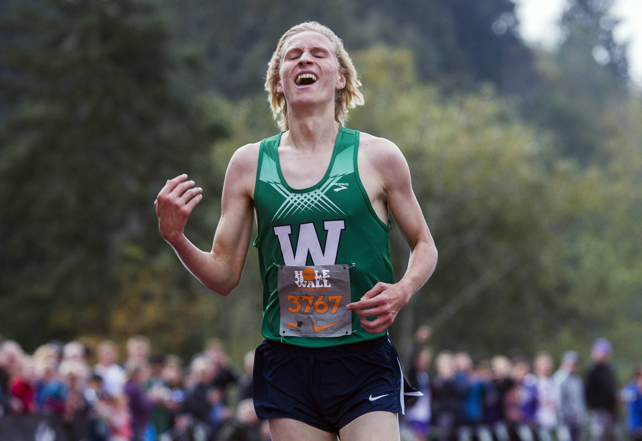 Woodinville’s Luke Houser smiles after breaking the race record during the Hole in the Wall Cross Country Invitational at Lakewood High School on Oct. 6 in Arlington. (Olivia Vanni / The Herald)