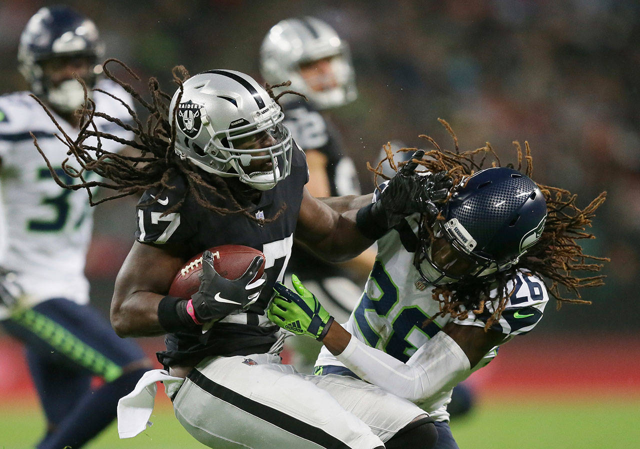 Seahawks cornerback Shaquill Griffin (26) tackles Oakland Raiders wide receiver Dwayne Harris during Sunday’s NFL game at Wembley Stadium in London. (AP Photo/Tim Ireland)