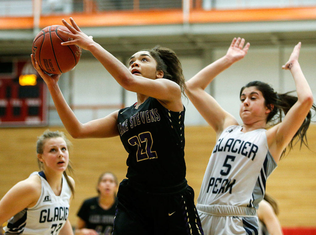 Lake Stevens’ Raigan Reed (22) goes to the hoop as she’s pursued by Glacier Peak’s Samantha Fatkin (5) during the Class 4A District 1 girls basketball championship game at Everett Community College on Thursday, Feb. 16, 2017. (Ian Terry / The Herald)
