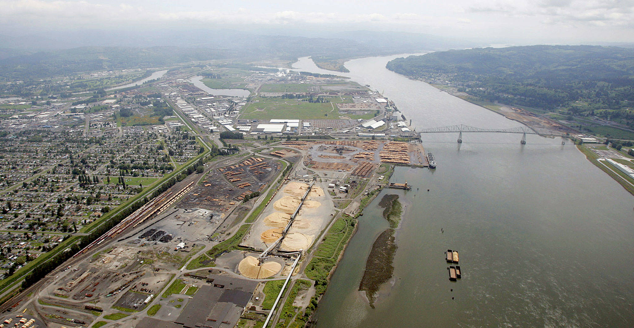 Timber-processing facilities line the banks of the Columbia River near the Port of Longview in Longview, Washington. A year after the state Ecology Department denied Millennium Bulk Terminals-Longview a key water quality permit in 2017 for a controversial coal-export project, the Army Corps of Engineers has revived an environmental review of a planned terminal on the river that would export coal to Asia. (AP Photo/Elaine Thompson, File)