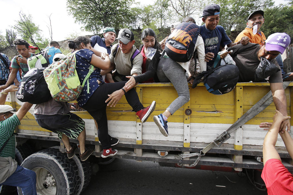 Honduran migrants bound to the U.S border climb into the bed of a truck in Zacapa, Guatemala, on Wednesday. (AP Photo/Moises Castillo)
