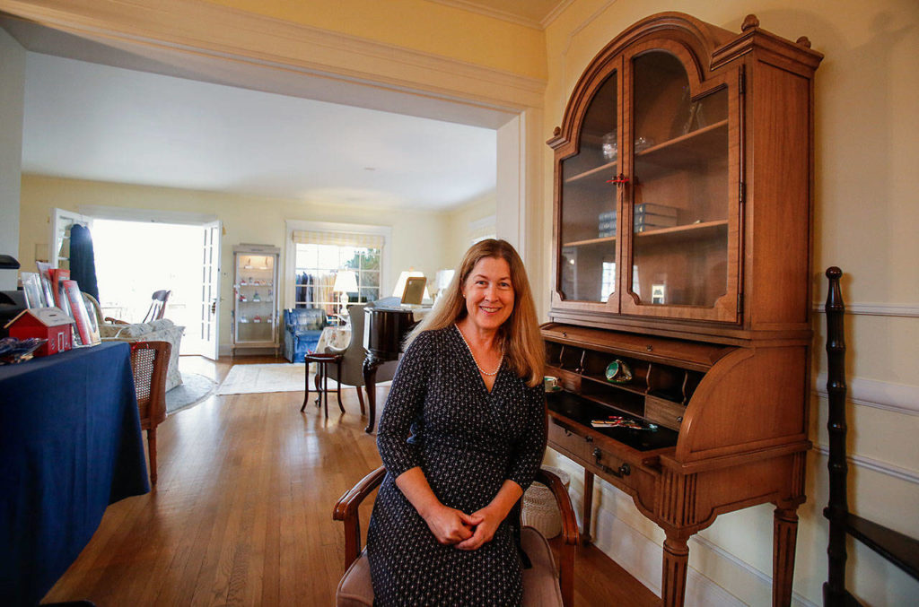 Anna Marie Laurence sits at her mother’s roll-top writing desk, a well-used treasure that will be sold. (Dan Bates / The Herald)
