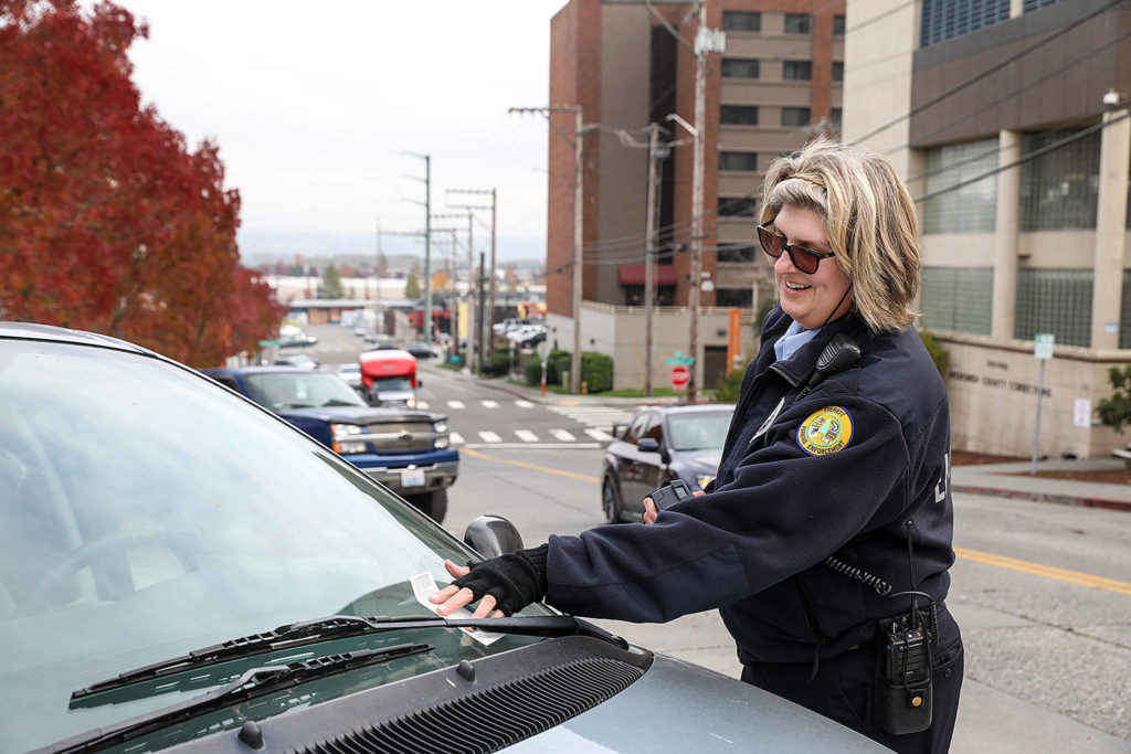 Parking enforcement officer Lori Garrett monitors vehicles parked downtown. The city hopes that increasing parking fines and moving to new enforcement software will reduce the number of vehicles staying past the time allowed. (Lizz Giordano / The Herald)
