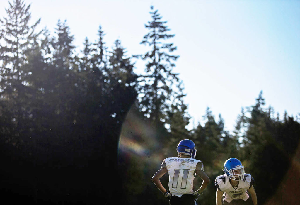 Two players wearing jerseys with “ohana” on the back run through a drill during football practice at South Whidbey High School on Oct. 16 in Langley. The ohana jerseys came about from a former coach Don Elliot and has become the “language of our team” according to head coach Mark Hodson. (Olivia Vanni / The Herald)
