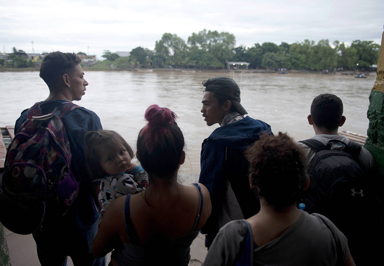 Honduran migrants wait on the edge of the Suchiate River on the border between Guatemala and Mexico, in Tecun Uman, Guatemala, on Friday. (AP Photo/Oliver de Ros)