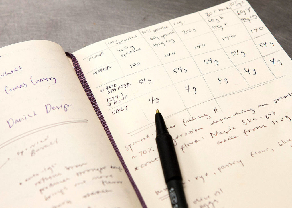 Notes on ingredients and measures, needed in baking bread, fill a notebook at The Bread Lab. (Andy Bronson / The Herald)
