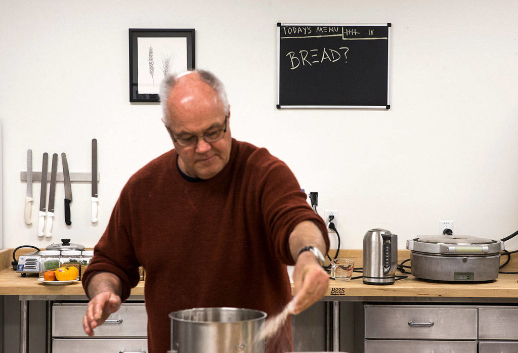 Bread is on the menu, as seen behind Andrew Ross from Oregon State University, who spreads out flour as he begins making bread at The Bread Lab. (Andy Bronson / The Herald)
