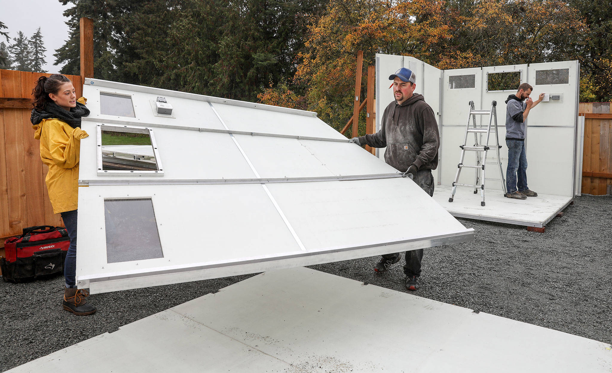 A crew from the company Pallet assembles tiny homes at a homeless encampment Thursday morning on the grounds of Good Shepherd Baptist Church in Lynnwood. (Lizz Giordano / The Herald)