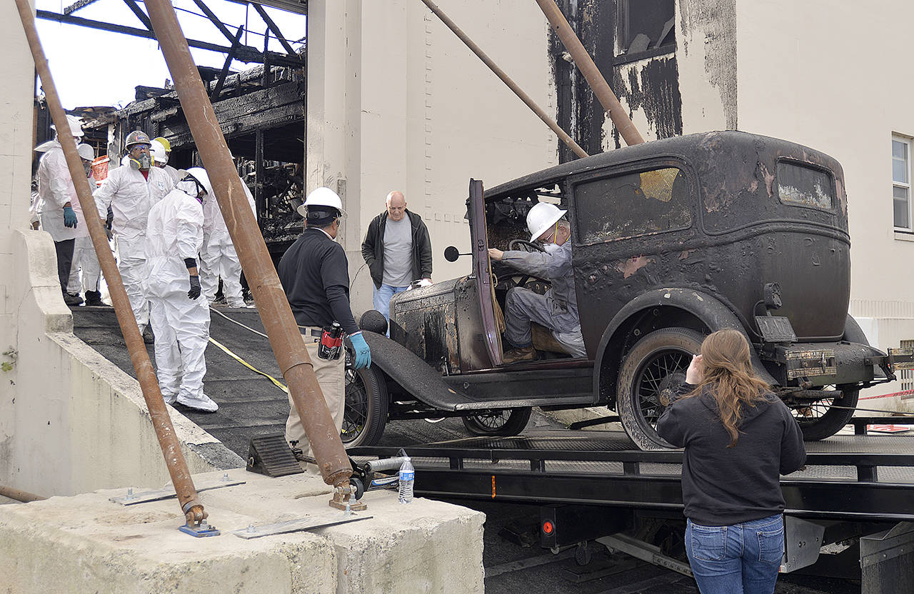 Ed Lind sits behind the wheel of his beloved 1929 Chevrolet as it’s towed out of the Armory Building, which was gutted by fire June 9. (Dan Hammock / The Daily World)