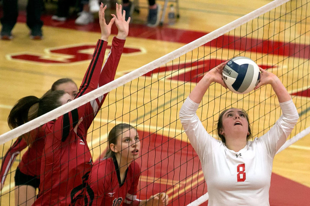 Stanwood’s Peyton Wickstrom (right) sets Thursday at Stanwood High School. (Kevin Clark / The Herald)
