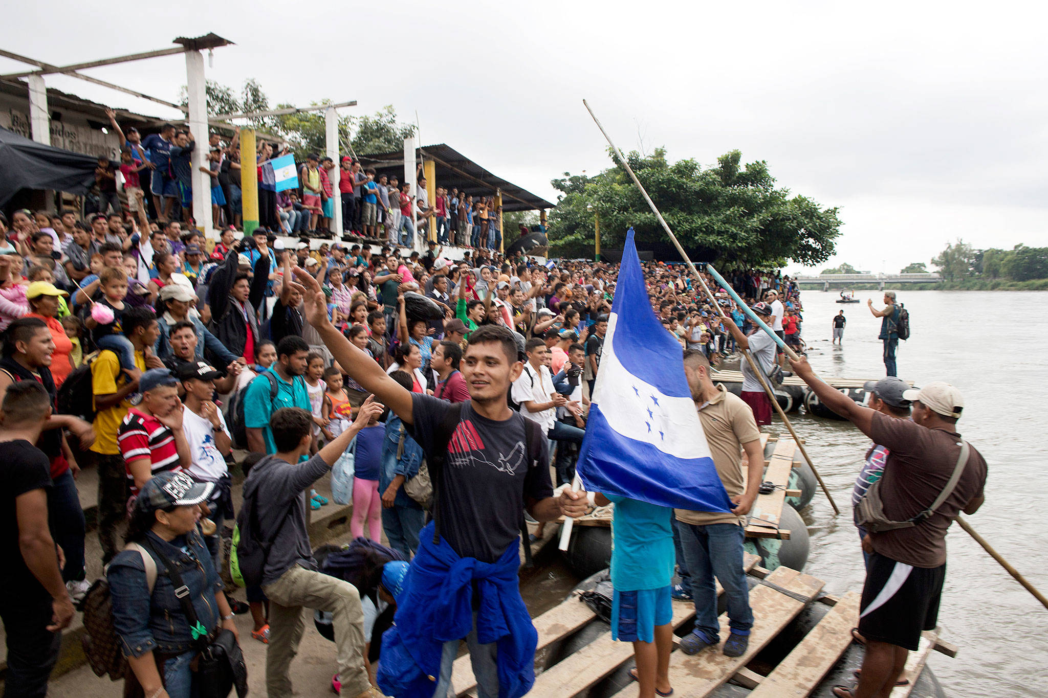 Hundreds of Honduran migrants stand at the shore of the Suchiate river on the border between Guatemala and Mexico, in Tecun Uman, Guatemala, on Thursday. Mexico’s foreign ministry says government officials at its southern border with Guatemala have started assisting the early arrivals from a caravan of some 3,000 Honduran migrants that has drawn sharp criticism from U.S. President Donald Trump. (AP Photo)
