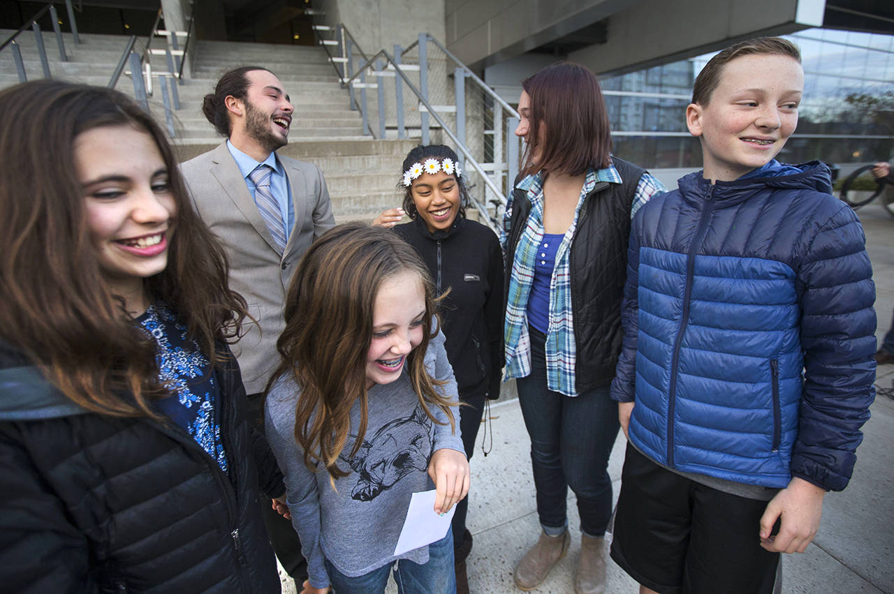 Five of the 21 youth plaintiffs in a federal climate change lawsuit against the federal government, including, from left, Sahara Valentine, 11, Jacob Lebel, 19, Avery McRae, 10, Miko Vergun, 15, Kelsey Julianna, 20, and Zealand Bell, 11, celebrate on the courthouse steps in 2016 in Eugene, Oregon, after U.S. District Judge Ann Aiken rejected requests from the federal government and trade groups representing many of the world’s largest energy companies to dismiss their lawsuit. (Chris Pietsch /The Register-Guard via AP, File)