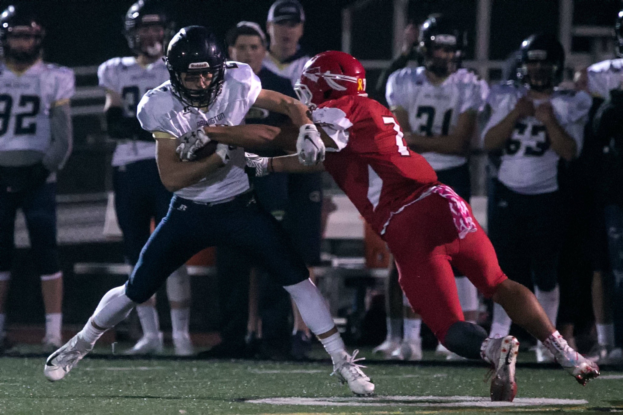 Arlington’s Bryce Petersen (left) makes a reception with Marysville Pilchuck’s Jared Kelly defending during a game on Oct. 19, 2018, at Quil Ceda Stadium in Marysville. (Kevin Clark / The Herald)