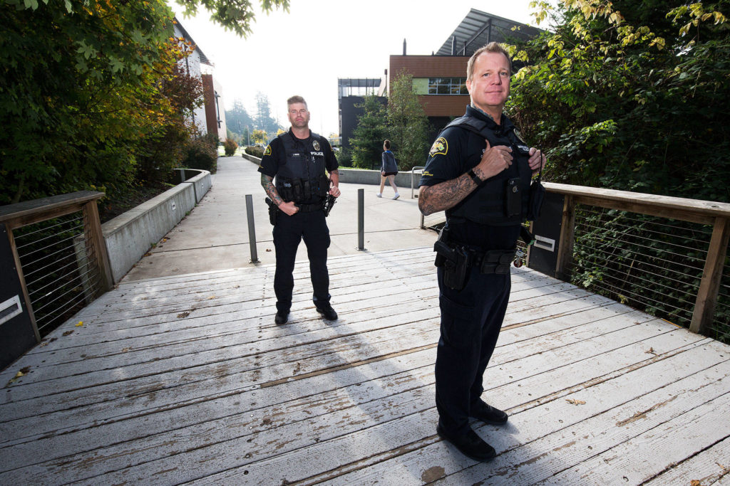 At Marysville Getchell High, School Resource Officers Chris Sutherland (right) and Jeremy Wood pose for a photo on Oct. 11. (Andy Bronson / The Herald)
