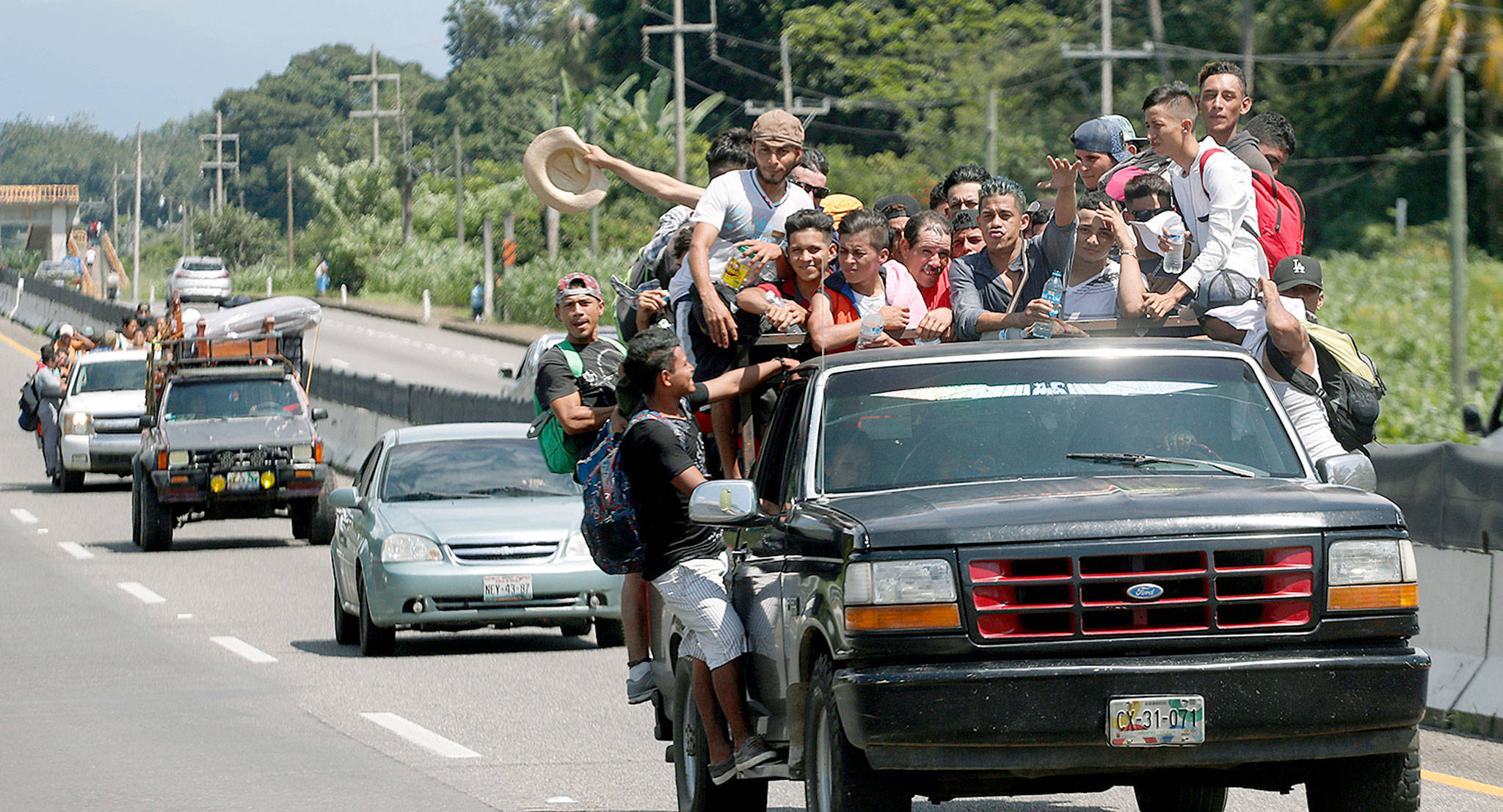 Central American migrants make their way to the U.S. in the truck of a driver who offered them the ride to Tapachula, Mexico, on Sunday. Despite Mexican efforts to stop them at the Guatemala-Mexico border, about 5,000 Central American migrants resumed their advance toward the U.S. border Sunday. (AP Photo/Moises Castillo)