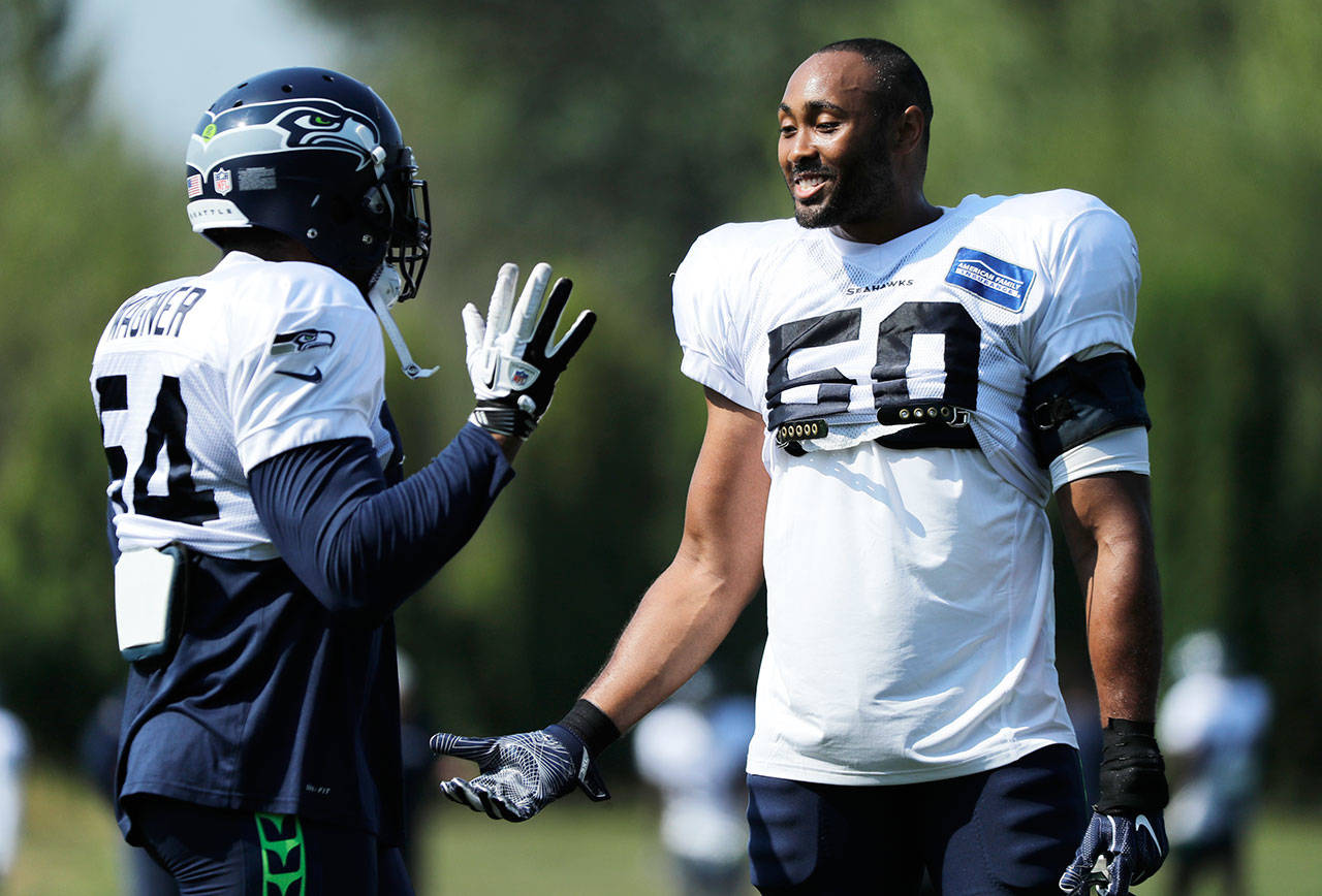 Seahawks linebackers Bobby Wagner (left) and K.J. Wright (right) talk during training camp on July 29 in Renton. (Ted S. Warren / Associated Press)